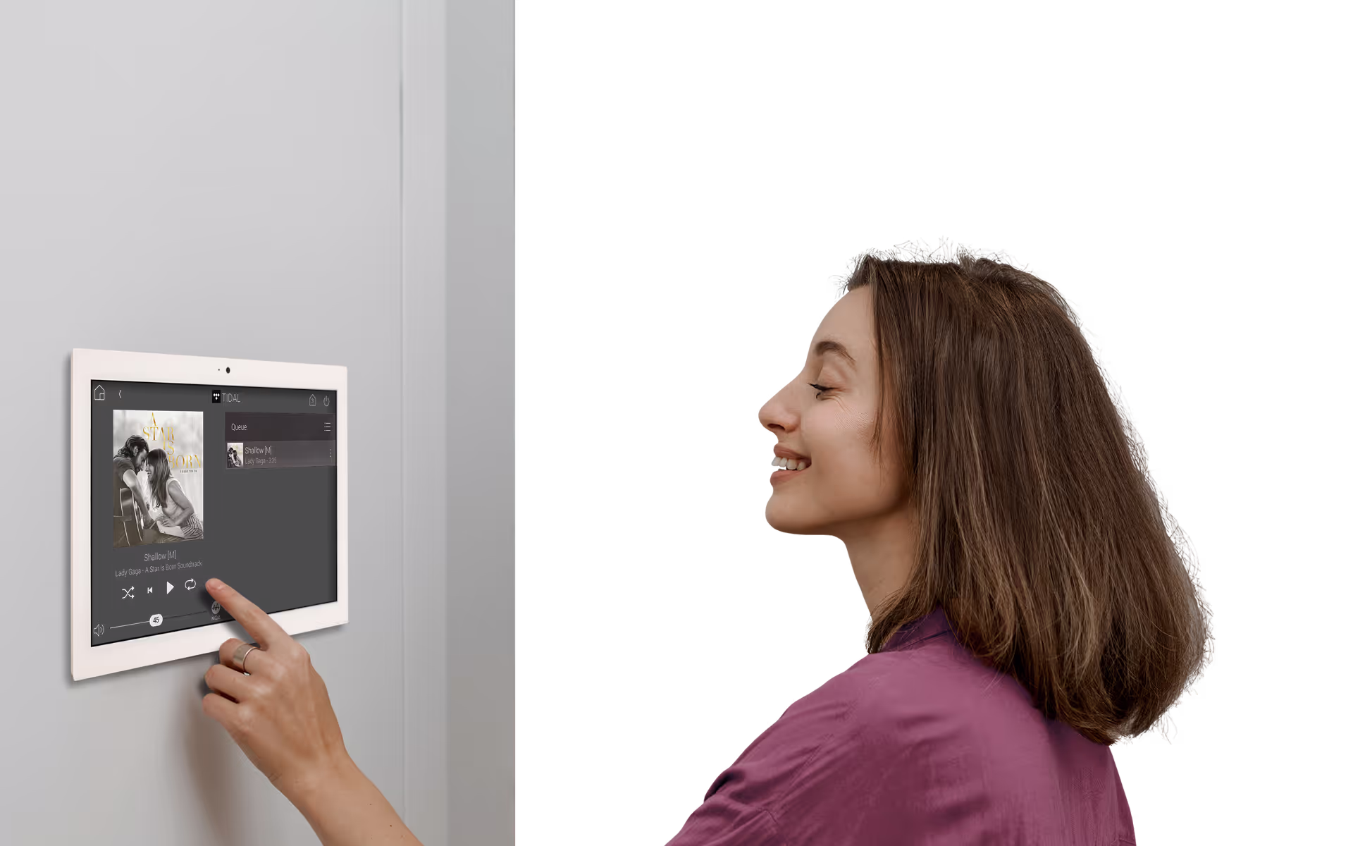 Music in Every Room lady controlling the music from ipad on the wall in her open plan home